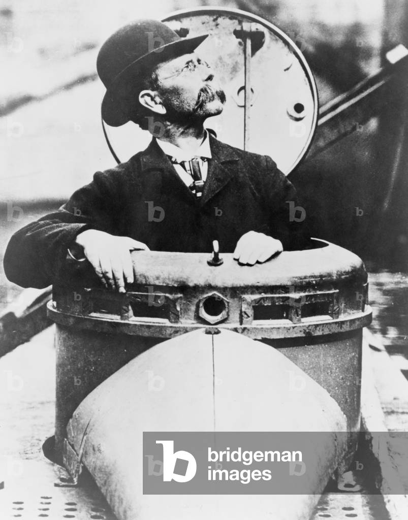 John P. Holland (1841-1914), climbing up hatch of his invention, the USS Holland submarine, the US Navy's first commissioned submarine, c. 1900 (b/w photo)