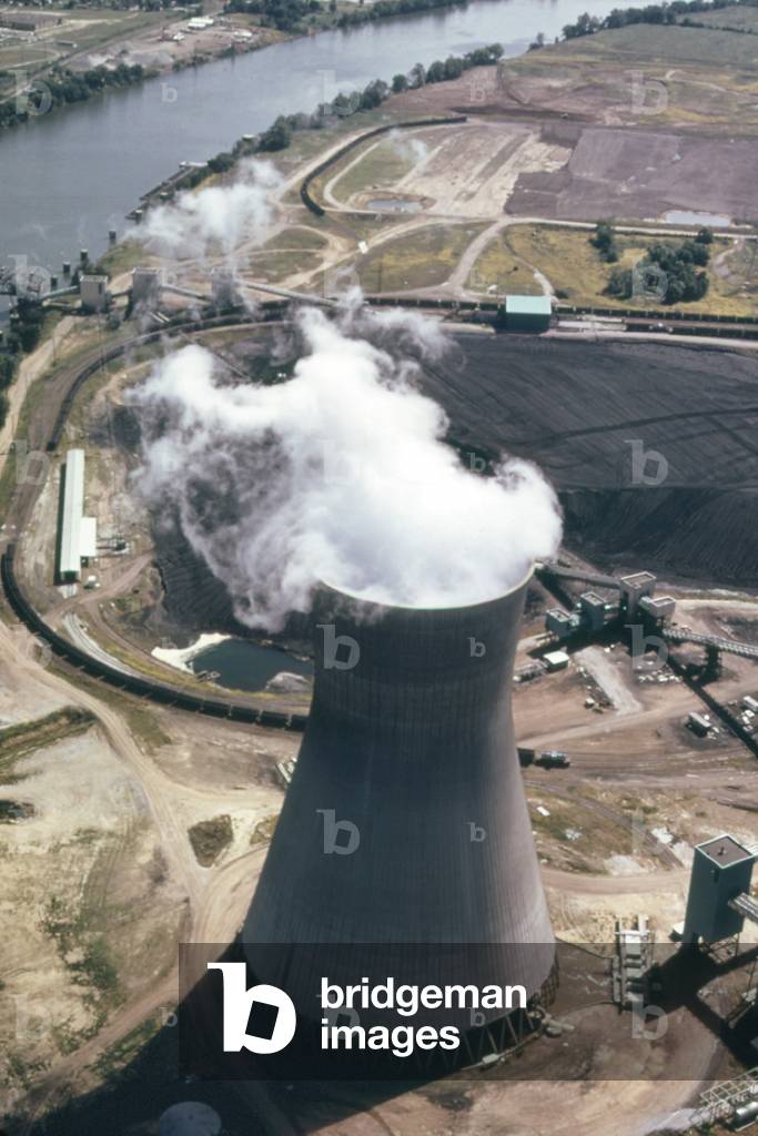 Steam rises from one of the massive cooling towers of the John Amos Power Plant which generates electricity from coal a abundant resource in West Virginia. c. 1973-75