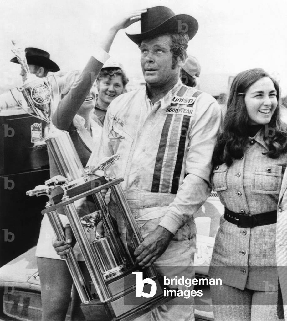 NASCAR racecar driver Buddy Baker after winning the Texas 500, Nov. 12, 1973. His average speed was 147.059 miles per hour. With him in victory circle is his wife, Coline