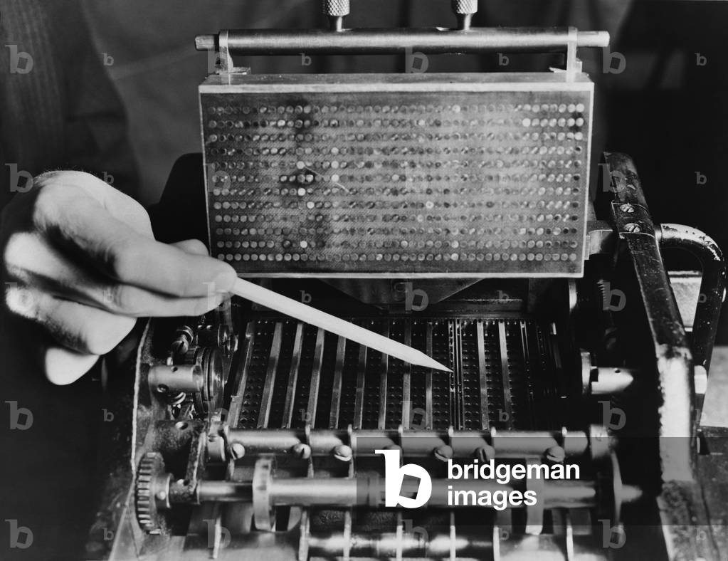U.S. Bureau of the Census computer operator pointing out the interior mechanism of the punched card sorter, c. 1940