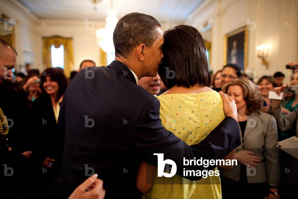 President Obama whispers into Michelle's ear during the White House Cinco de Mayo celebration. Michelle wears an acid green satin dress from Mocshino's 2009 Spring/Summer collection.,