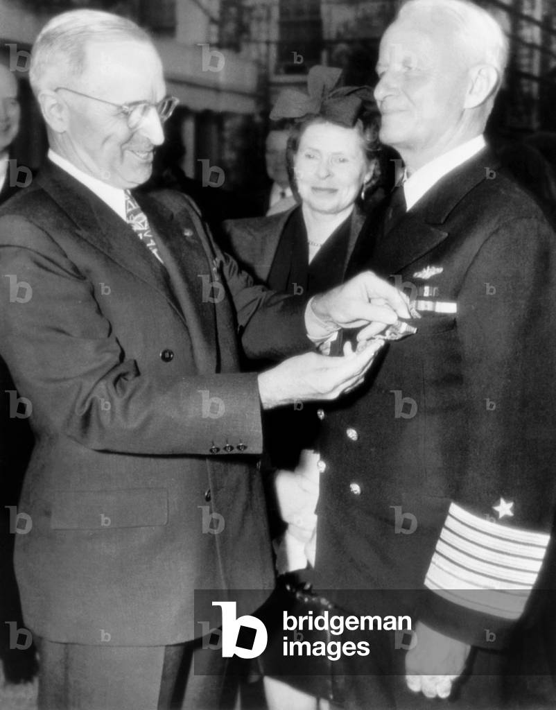 President Harry Truman, left, decorating Fleet Admiral Chester Nimitz, while Catherine Nimitz, looks on, outside the White House, October 5, 1945
