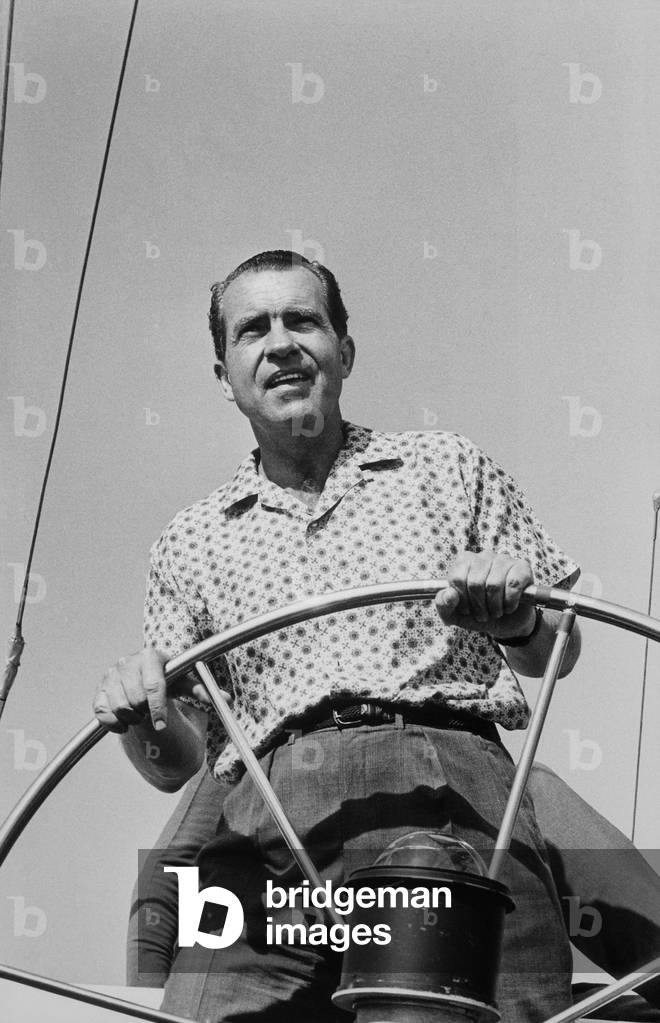President Richard Nixon behind the wheel on of a boat. c. 1969-74
