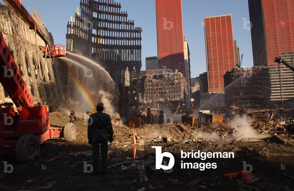Workers spray the still smoldering rumble with water at the World Trade Center site six weeks after the 9-11 attacks. Orange netting covers damaged buildings adjacent to Ground Zero. Oct. 28 2001