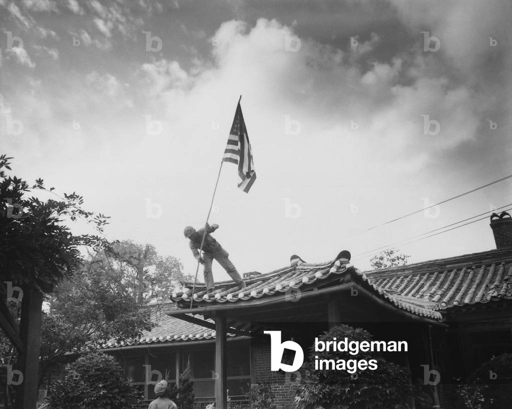 Marine raises U.S. flag at American consulate in Seoul, while fighting for the city raged around the compound. 2nd Battle of Seoul, Sept. 27, 1950. Korean War, 1950-53