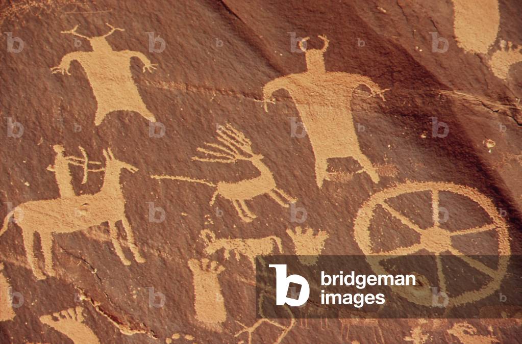 Newspaper Rock Is a large cliff mural of ancient Indian petroglyphs and pictographs. This detail shows a rider on a horse and human figures. Images were made by Native Americans during both the prehistoric and historic periods