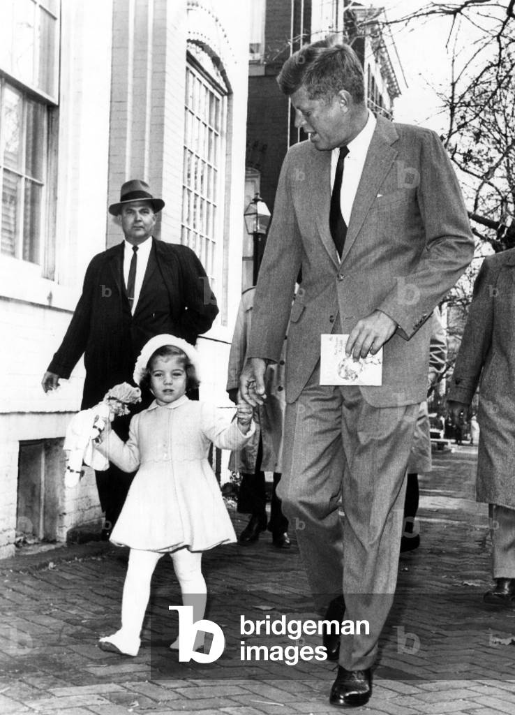 President-elect John F. Kennedy, and Caroline Kennedy, walk to church from their home on her third birthday. John F. Kennedy holds a children's prayer book, November 27, 1960