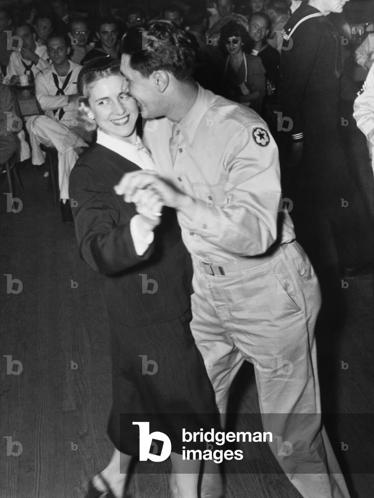 Congresswoman Clare Booth Luce dances with a G.I. at the Washington, D.C. Canteen. She was serving as a Congressional hostess during celebration of the first birthday of 'the service man's heaven'. Sept. 30, 1943