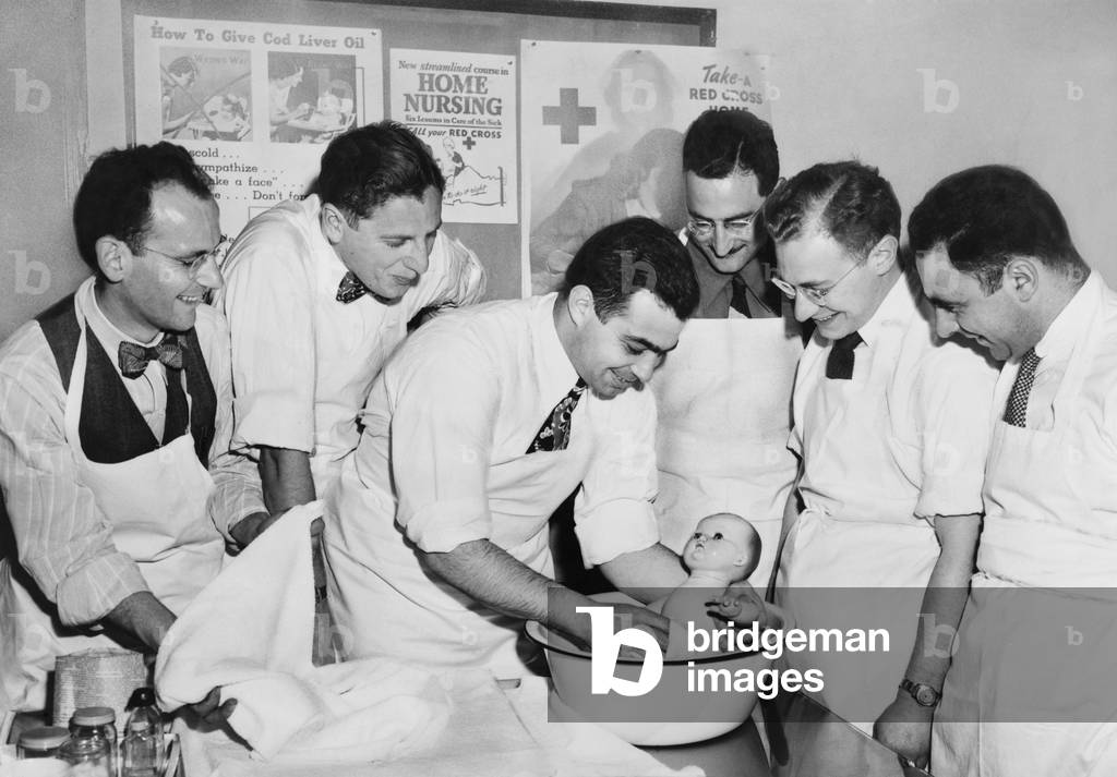Expectant fathers bathing a doll during an infant care class at the Brooklyn Red Cross Headquarters. 1947