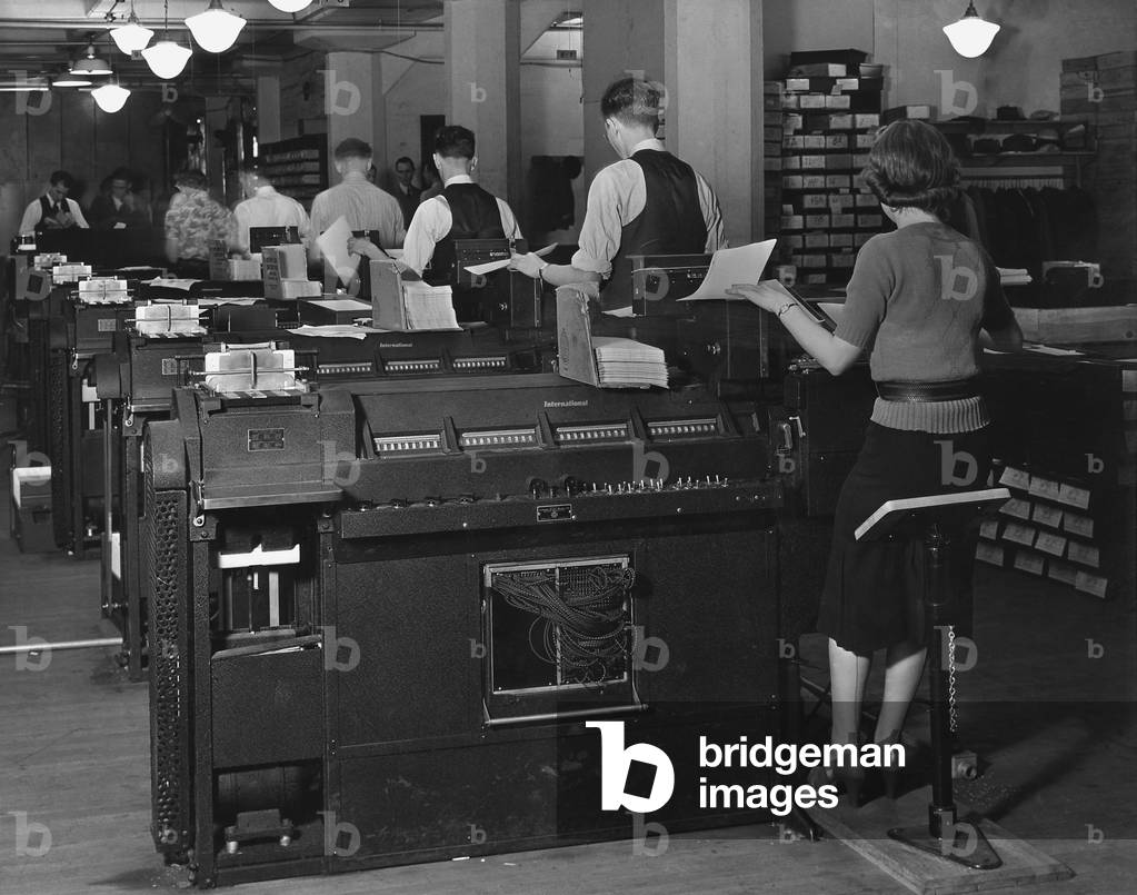 Social Security Administration clerks seated at massive tabulating machines, actually early computers, used to manage the individual records of millions of Americans in the Social Security system. c. 1940