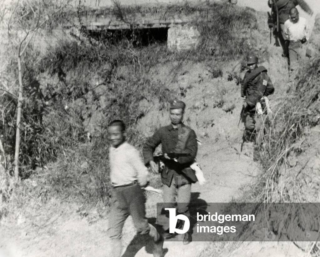 Chinese Communist soldiers are taken from a tower captured by government forces. The fighting took place along the border of Kiangsi and Fukien provinces in January 1934.