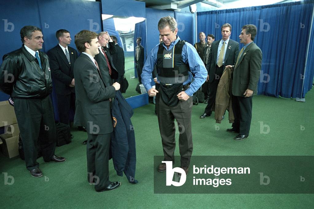 President George W. Bush puts on a vest before the first pitch in Game 3 of the World Series. At left is CIA Director, George Tenet