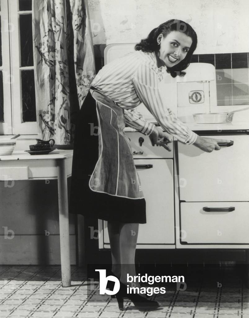 African American actress Lena Horne at a gas stove. She was promoted fuel conservation during World War 2, c. 1942-45