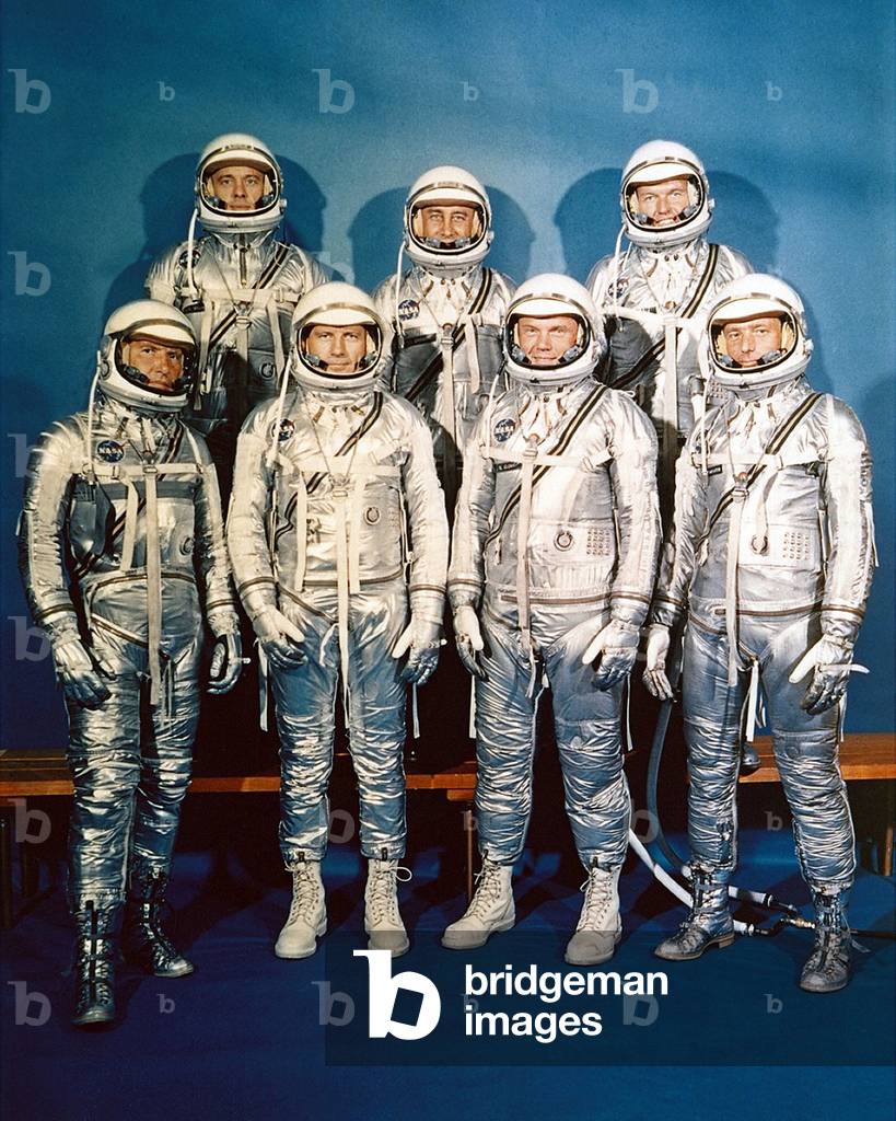 Project Mercury astronauts in their space suits. Front row, left to right, Walter H. Schirra Jr., Donald K. Slayton, John H. Glenn Jr., and Scott Carpenter; back row, Alan B. Shepard Jr., Gus Grissom, and L. Gordon Cooper. 1959