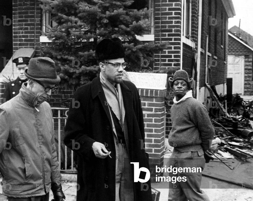 Malcolm X talks to a reporter after a bomb was thrown in his house, 1965 (photo)