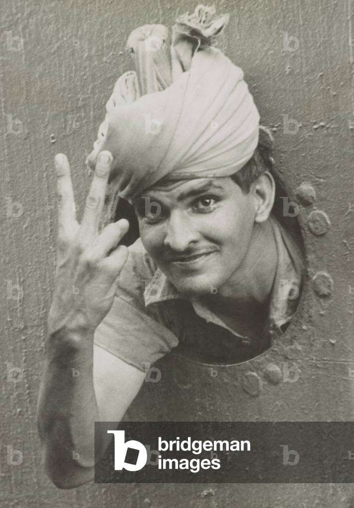 British Indian soldier he gives the 'V' sign from a port-hole of a ship on arrival in Singapore. Dec. 1941. World War 2