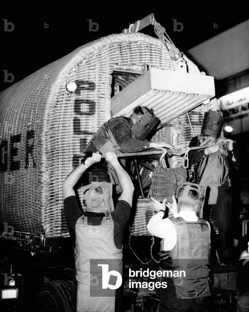 Police dispatch a suspected bomb found in a bus terminal locker. The police bomb squad wear protective masks and shields as the place a suspected bomb in a wicker lined truck. July 2, 1966