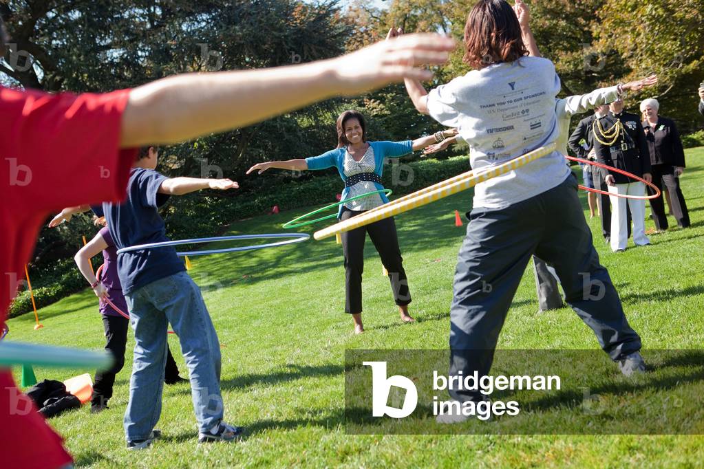 Michelle Obama hula hoops with children during the Healthy Kids Fair on the South Lawn of the White House Oct. 21 2009.,