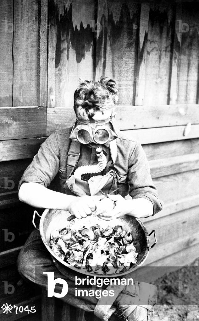 U.S. soldier putting his respirator to good use while peeling onions. 40th Division, Camp Kearny, San Diego, California. World War I. March 1918