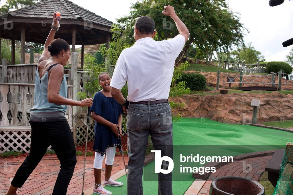 President and Michelle Obama react to daughter Sasha's hole in one while playing miniature golf at Pirate's Island Golf in Panama City Beach Fla. Saturday Aug. 14 2010.,