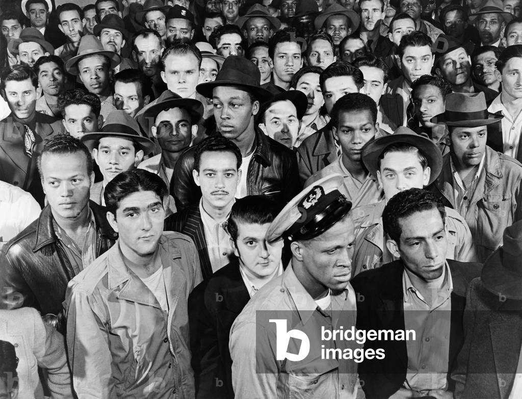 Sailors in the National Maritime Union hiring hall for deck and engine hands, watching the board where the jobs are posted. New York, c. 1955