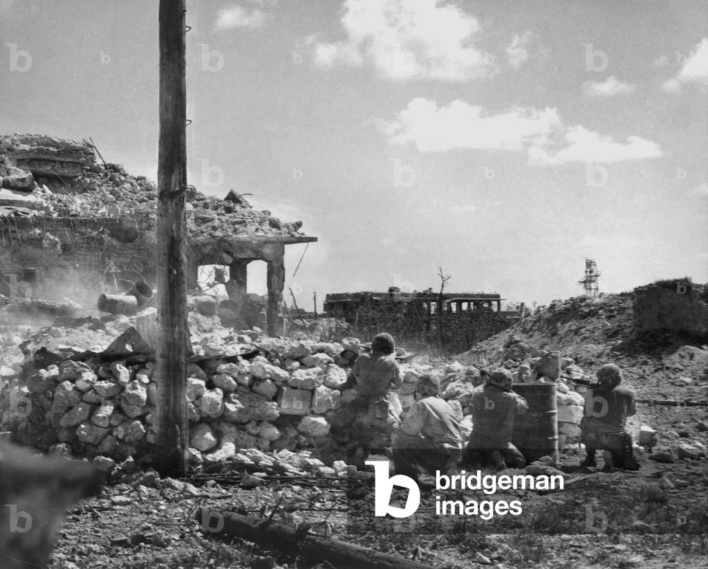 Marines of the First Division fire on Japanese snipers in a building on Peleliu Island. Sept.-Nov. 1944. World War 2, Pacific Ocean