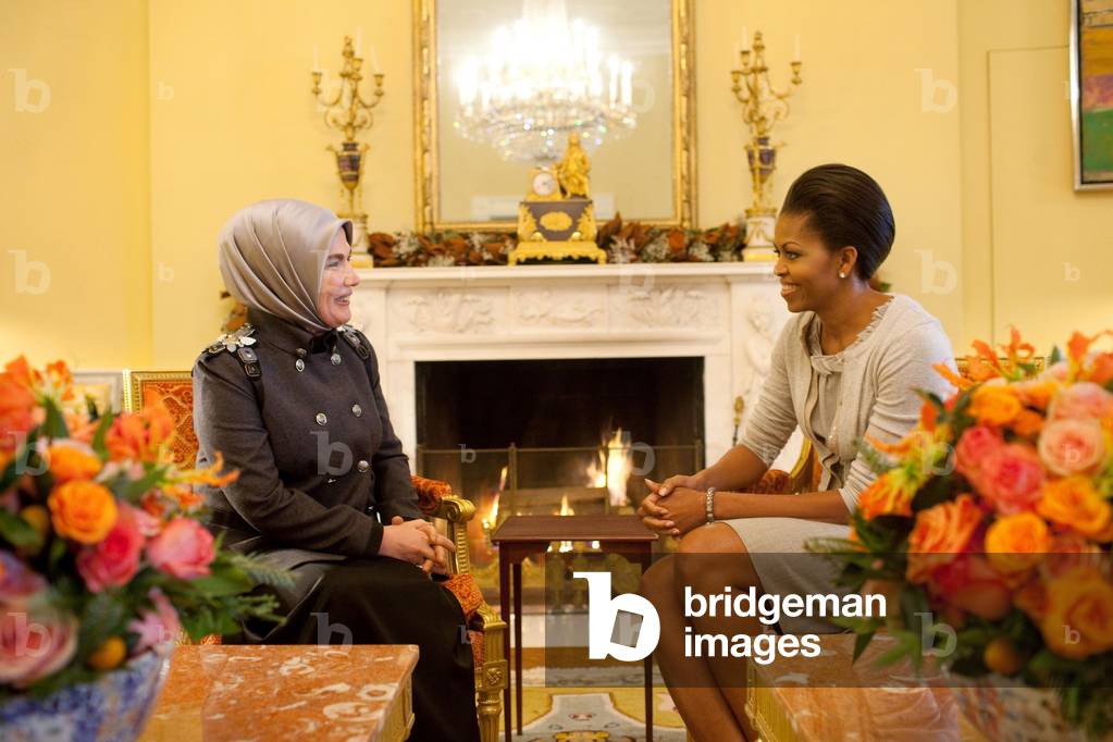 First Lady Michelle Obama meets with Ermine Erdogan wife of the Prime Minister of Turkey in the Yellow Oval Room of the White House. Michelle wears a beige shift dress and cardigan by J. Crew. Dec. 8 2009.,
