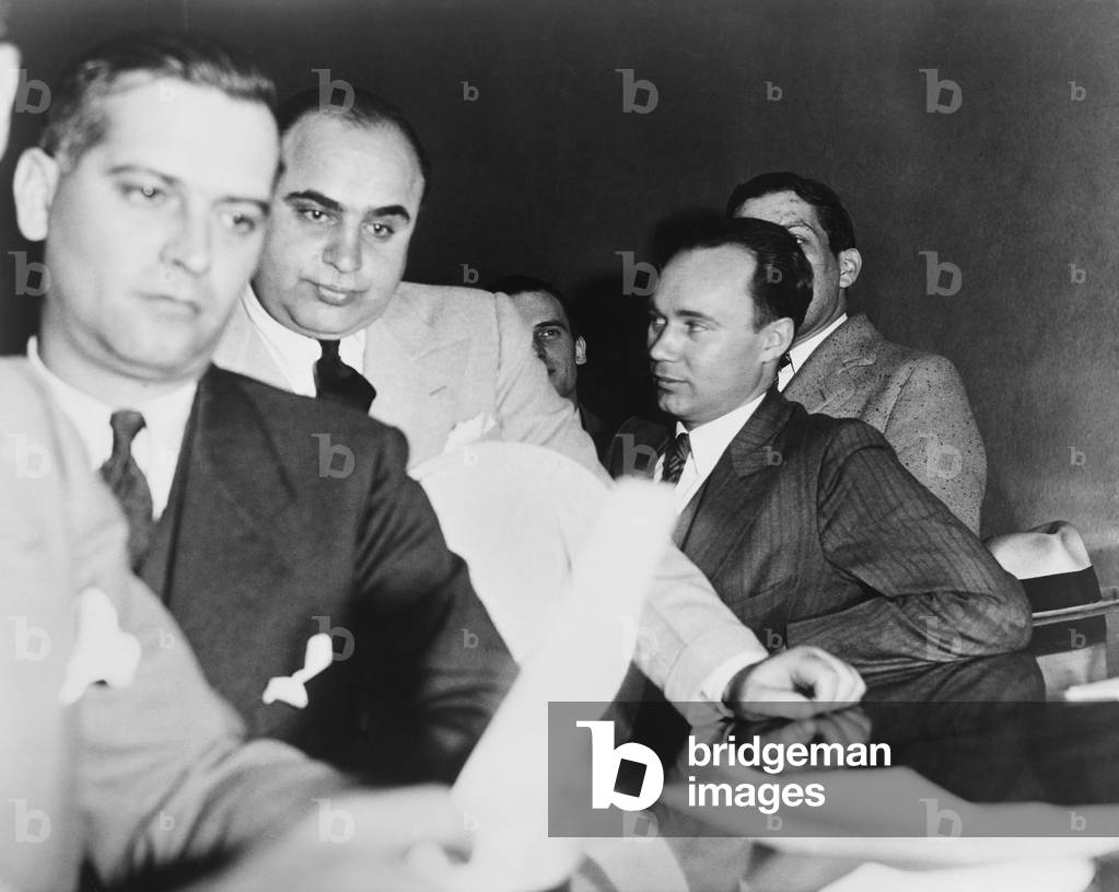 Al Capone, at the time of his indictment for tax evasion, June 5, 1931. At right is one of Capone's attorneys, Michael Ahern.