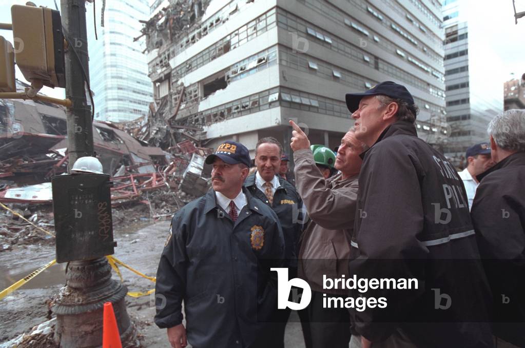 President George W. Bush visits World Trade Center ruins in New York, Sept. 14, 2001. With him from left are: NYC Police Commissioner Bernie Kerik; Sen. Chuck Schumer; and NY Gov. George Pataki. The group is on Vesey Street, on the north side of the World Trade Center complex