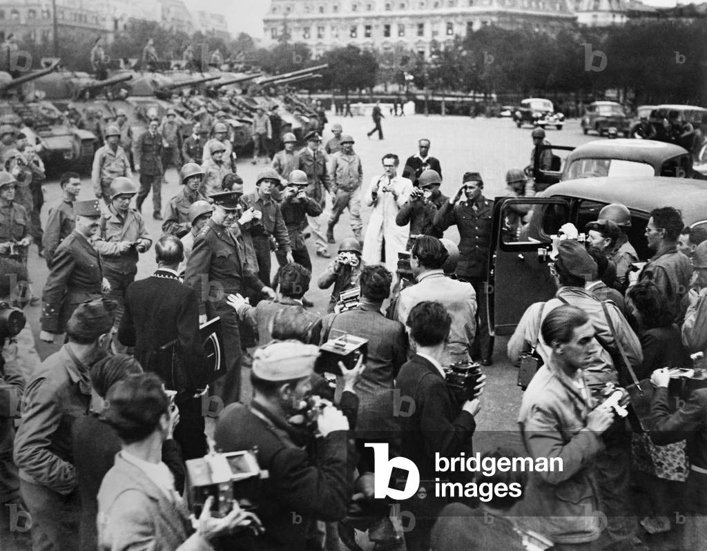General Eisenhower at Paris's Hotel de Ville (city hall) after the liberation of Paris. Surrounded by photographers and soldiers, he is followed by Marie-Pierre Koening of the Free French Forces. In the background are tanks of the French Division Leclerc. World War 2