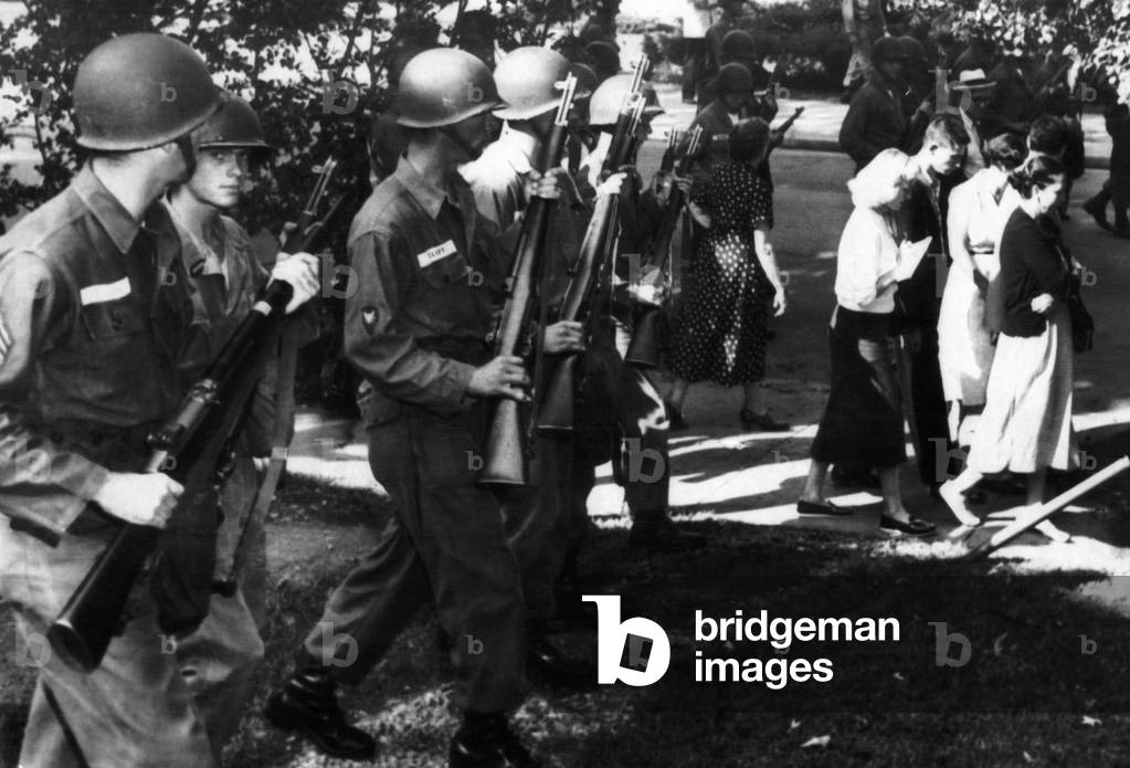 Troopers order parents and students who joined a protest march at Central High School in Little Rock, Arkansas to move away from school grounds. They were protesting the attendance of nine black students at the school, 1957