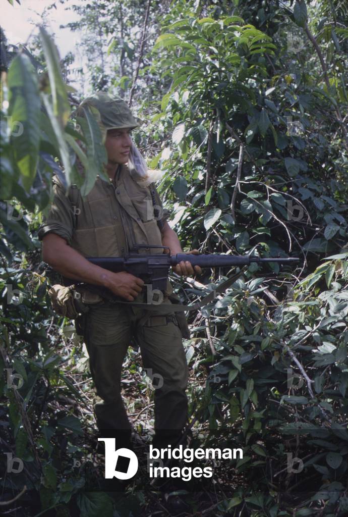 Vietnam War. US Marine moves through heavy grass in a deserted rice paddy while on patrol during a search and destroy operation in Quang Tri Province. Nov.-Dec. 1967