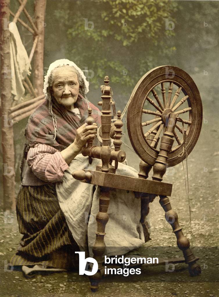 Elderly Irish Spinner working outdoors at her spinning wheel in the late 19th century. While picturesque, home spinning as late as 1900 indicated Ireland's the slow economic development and lack of industrialization. Galway County, c. 1900
