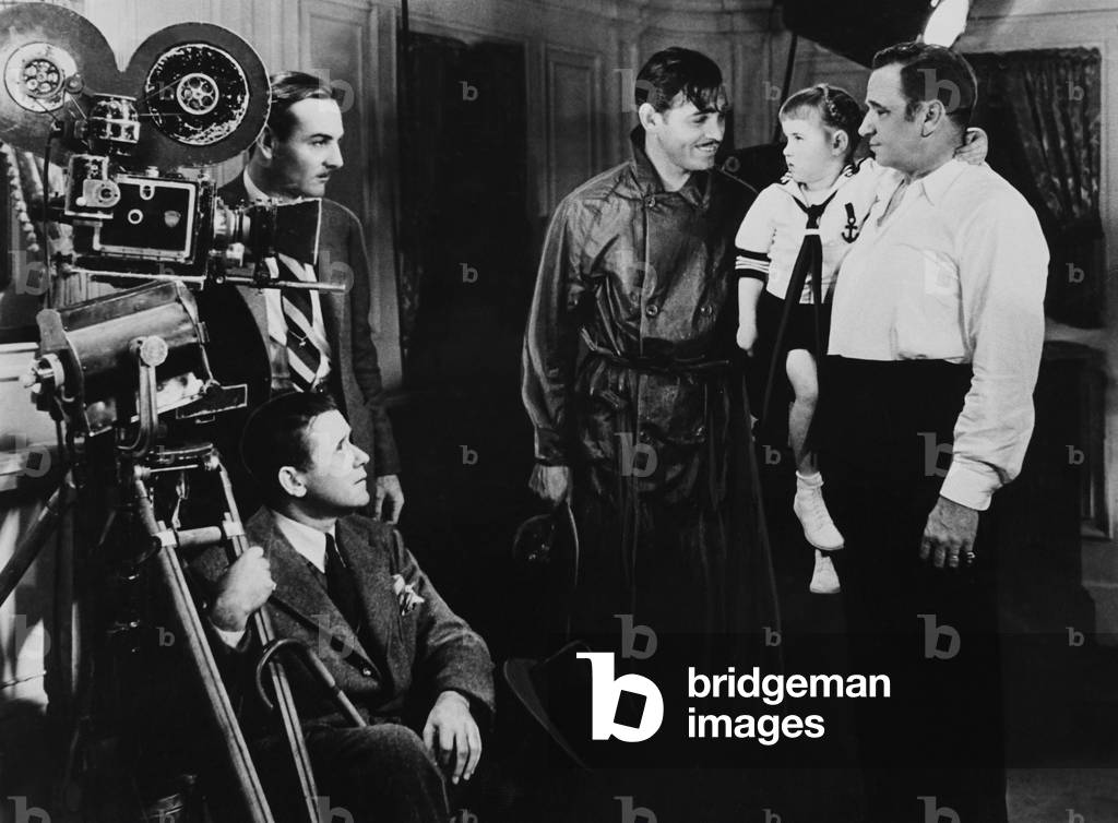 CHINA SEAS, from left: cinematographer Ray June, director Tay Garnett (seated), Clark Gable, Wallace Beery holding his daughter Carol Ann Beery on set, 1935