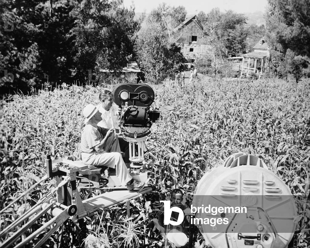 FRIENDLY PERSUASION, from left: director William Wyler (seated), camera operator Emmett Bergholz on location in a corn field, 1956
