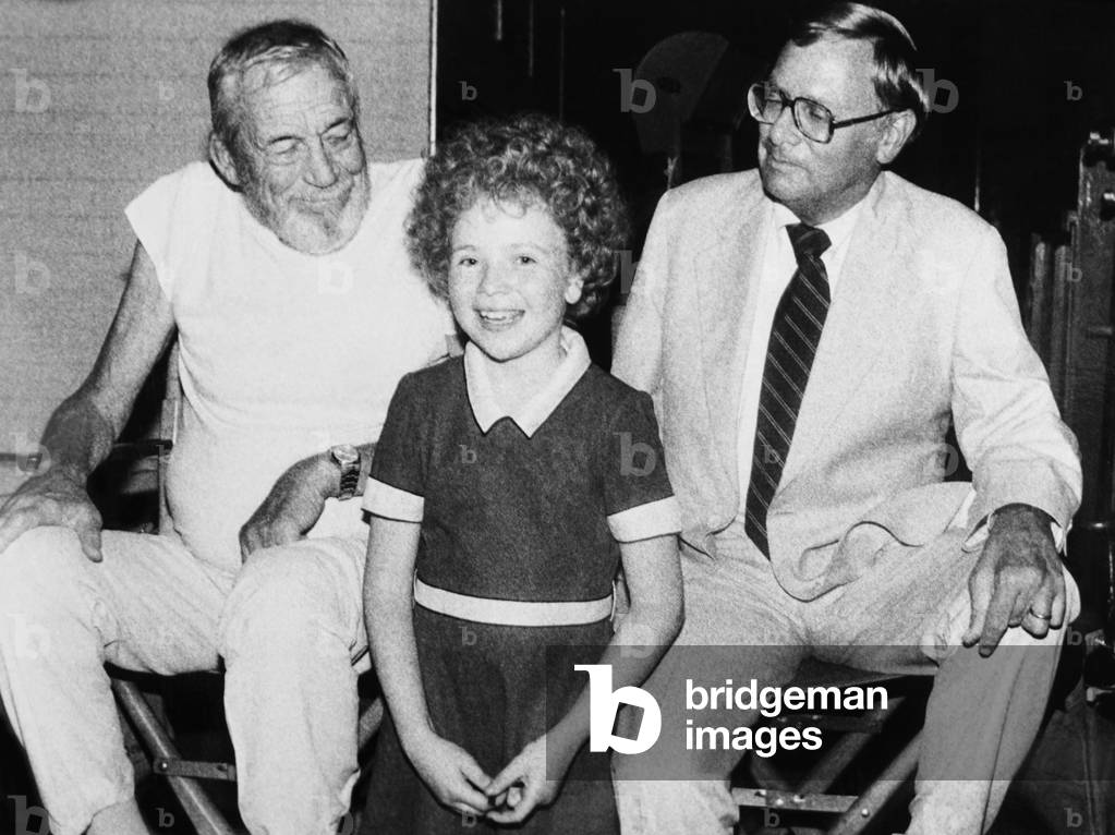 ANNIE, from left: director John Huston, Aileen Quinn, producer Ray Stark on set, 1982,