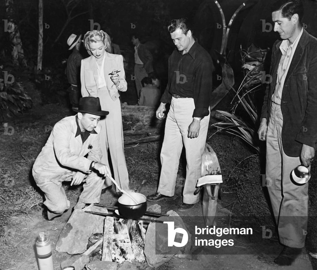ANGEL ON THE AMAZON, from left: director John H. Auer (kneeling), Constance Bennett on set, 1948