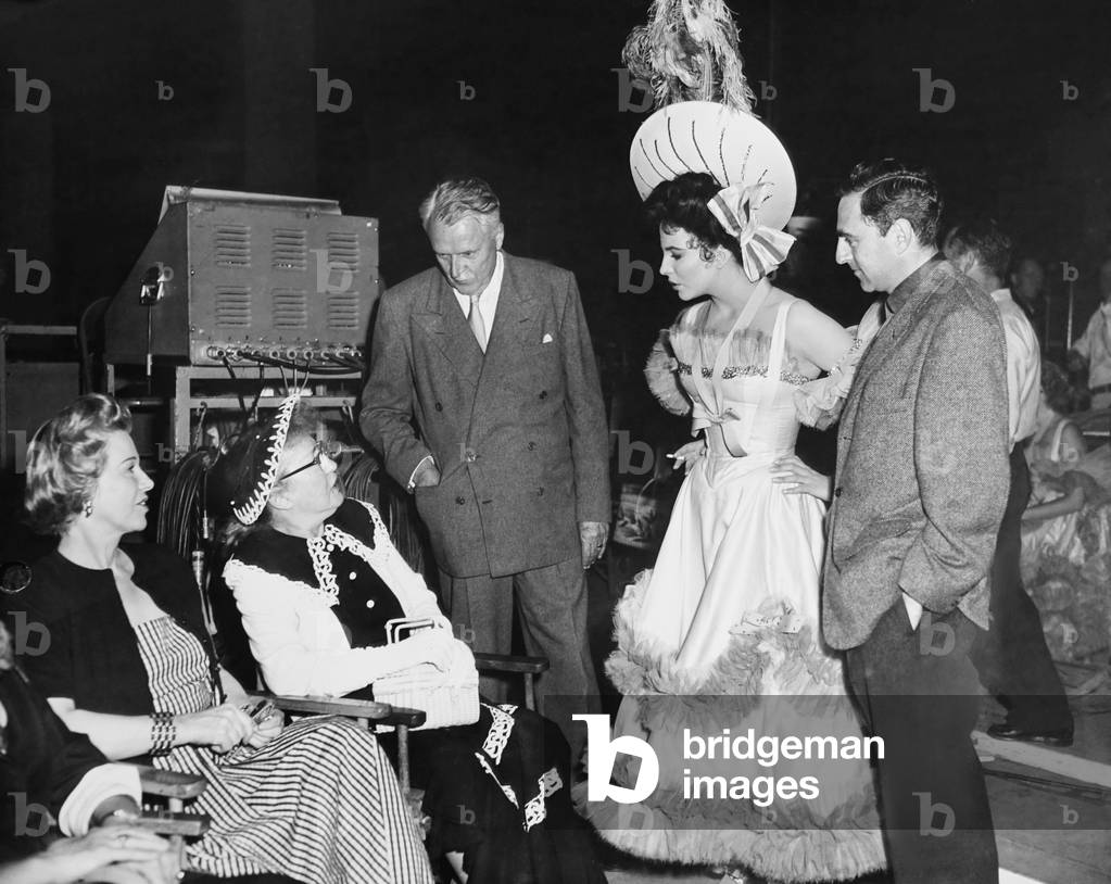 THE GIRL IN THE RED VELVET SWING, standing from left: producer Charles Brackett, Joan Collins, director Richard Fleischer on set, 1955