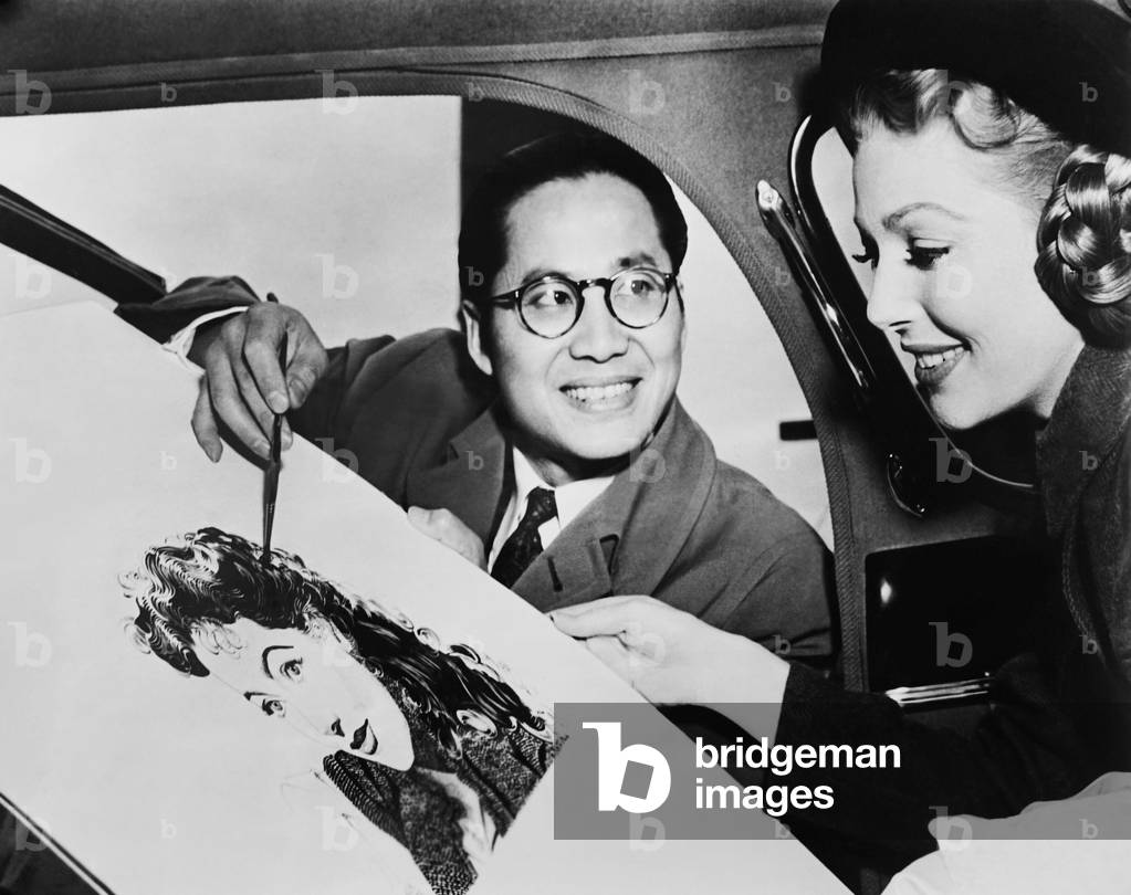 THE FARMER'S DAUGHTER, from left: Keye Luke showing Loretta Young the sketch he has made of her on set, 1947