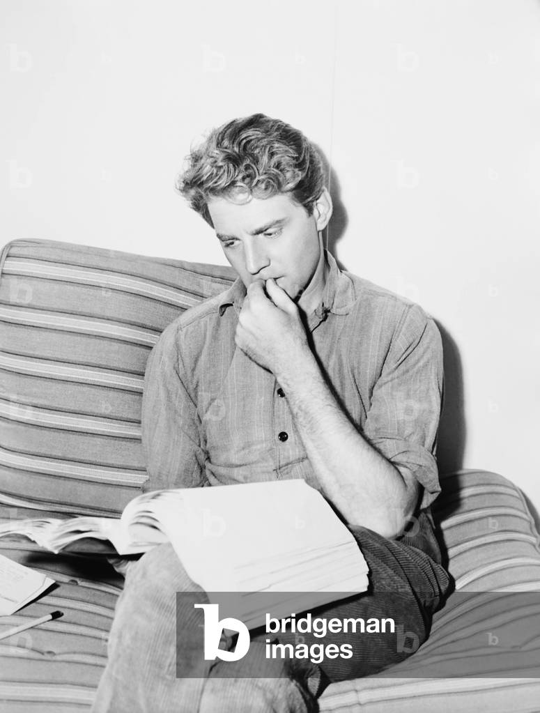 THE CROSS OF LORRAINE, Jean-Pierre Aumont studying his script on set, 1943