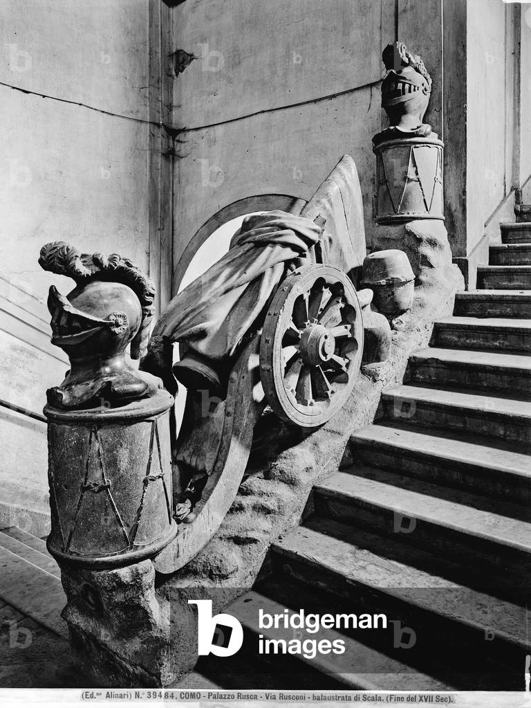 Balustrade of the stairway of Palazzo Rusca in Como, with sculptures depicting crested helmets and a wheel.