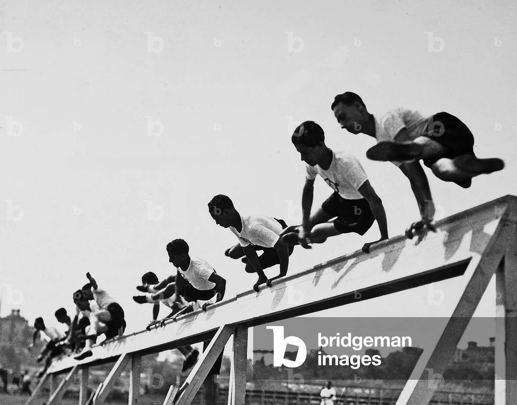 Athletes, of the Fascist Academy, portrayed while jumping a hurdle