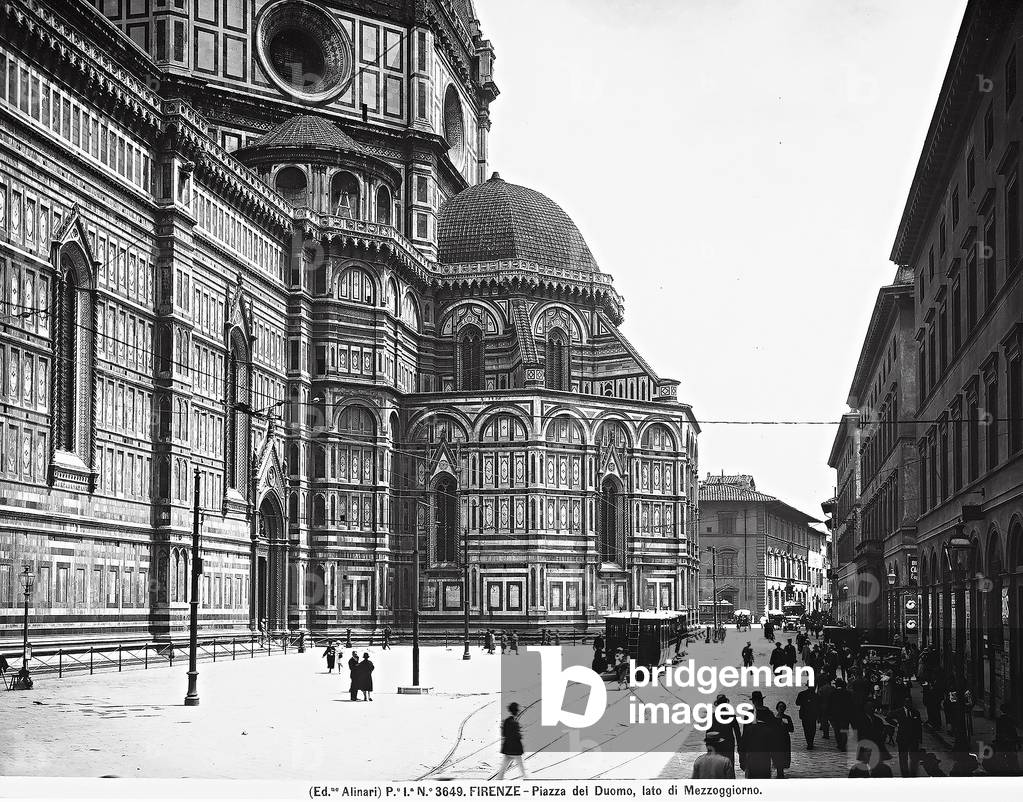 View of the Duomo and the piazza omonima animated by passers-by. Florence