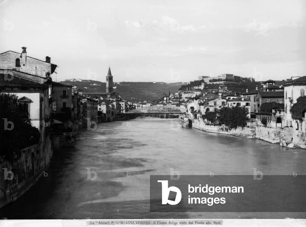 View of the Adige river from the Ponte delle Navi. In the background, a panorama of the town of verona and the hilly landscape.
