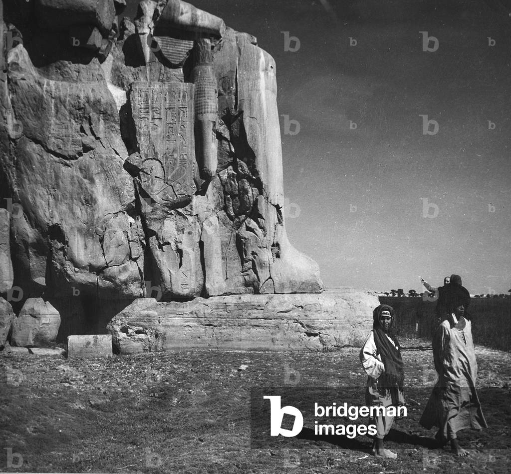 Egyptians and tourists next to a colossal statue, Egypt
