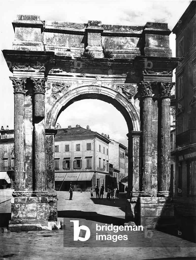 Arch of Sergi in Pola, photographed during the period of Italy's reign in Istria. The arch has a single barrel vault and flanked by corinthian columns.