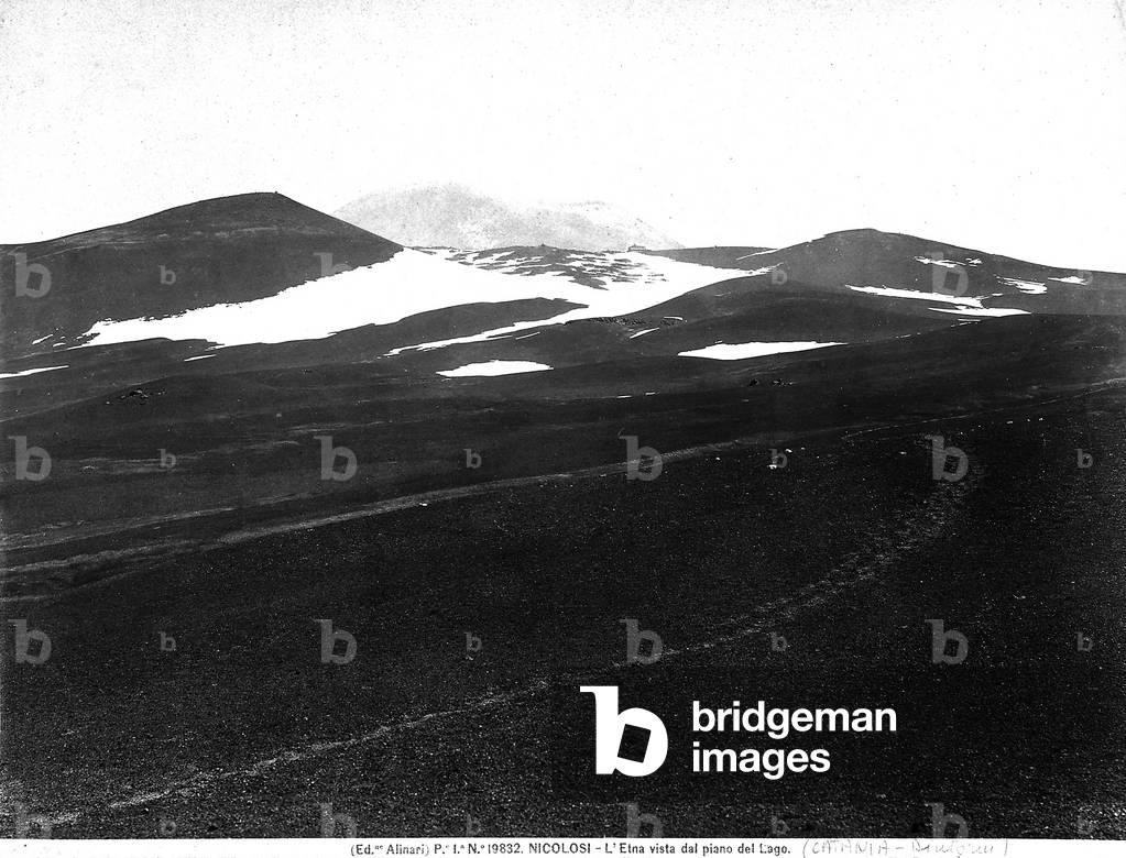 View with people of the snow-clad Mount Etna and one of its craters