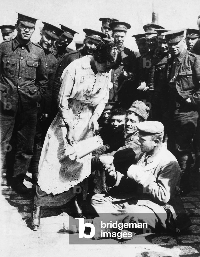 French lady who assists some wounded German prisoners, sitting on the ground,  1914-1917 (b/w photo)
