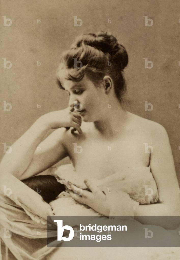 Half-length portrait of a young woman, partially nude.
