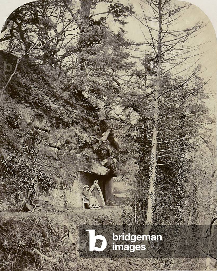 Women resting along a road going through the middle of a forest